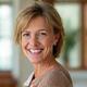 Lisa, a woman in her late 40s, smiling brightly after improving her digestive health.